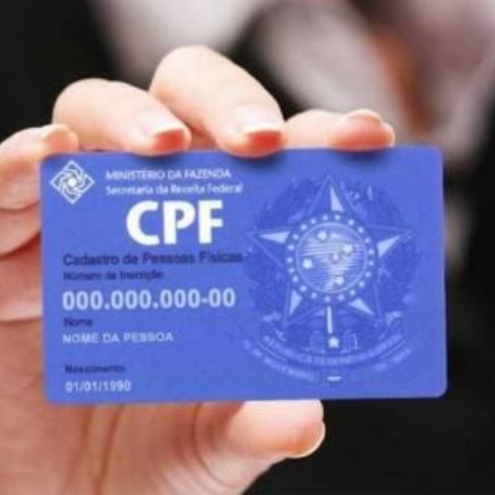 Mãos segurando o cartão de CPF, documento essencial para o estrangeiro que chega ao Brasil