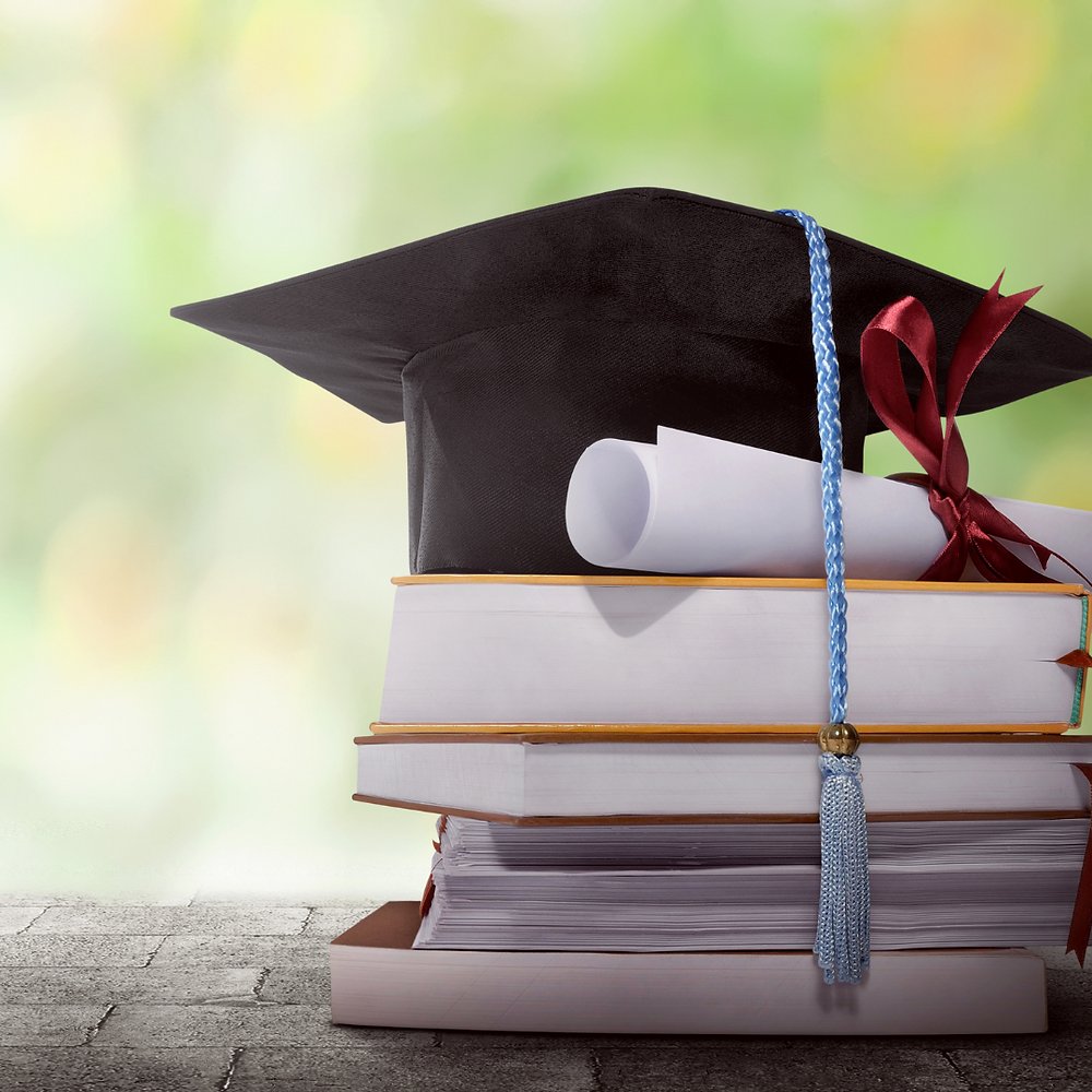Capelo de formatura sobre pilha de livros, revalidação de diplomas estrangeiros no Brasil